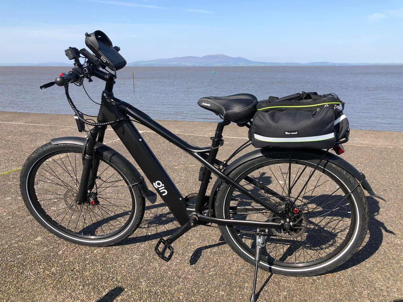 Black PLUTO e-bike parked on a beach