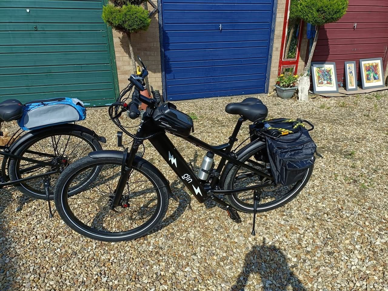 Two PLUTO e-bikes in front of colourful garage doors